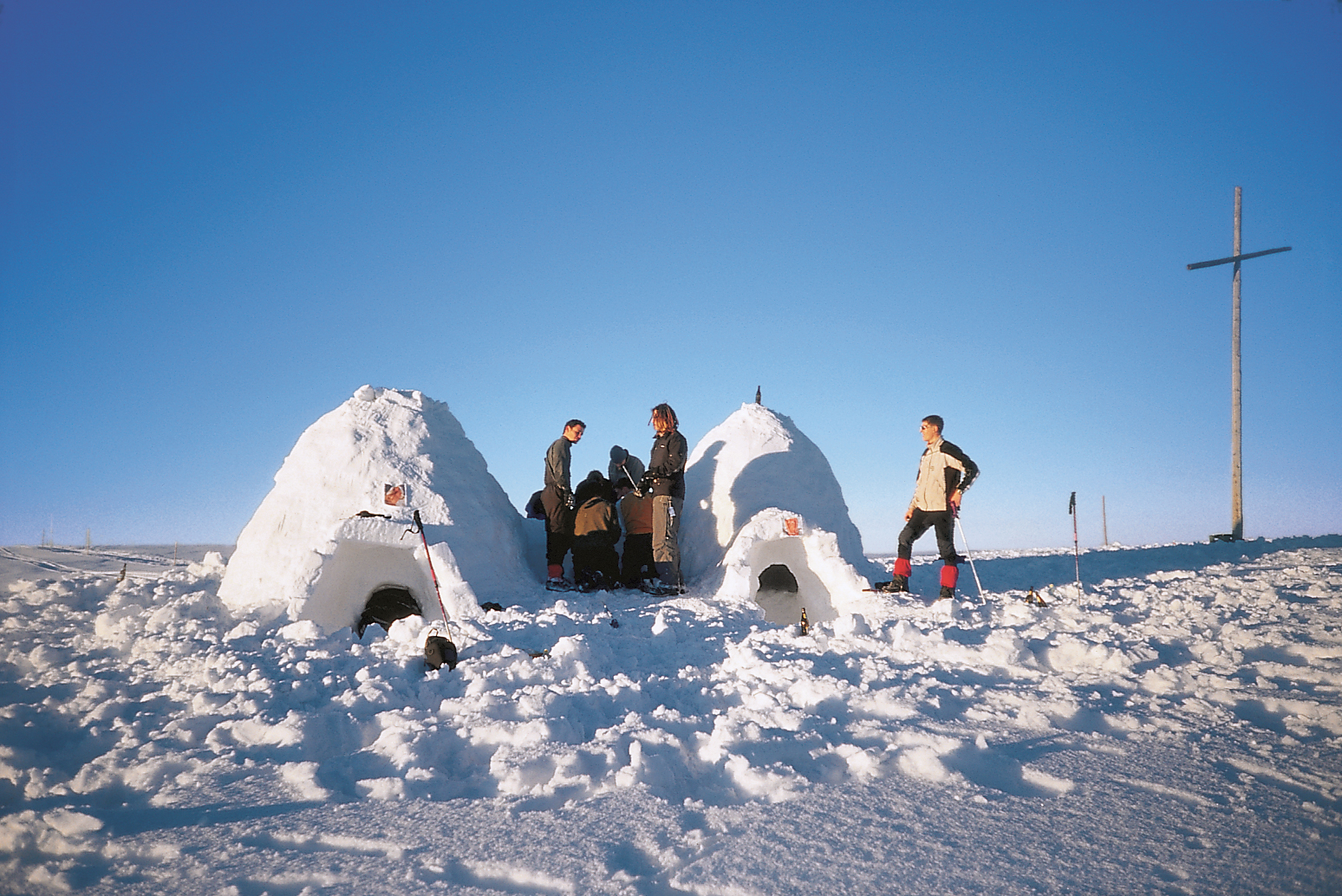 Gruppe beim gemeinsamen Iglubau in verschneiter Berglandschaft