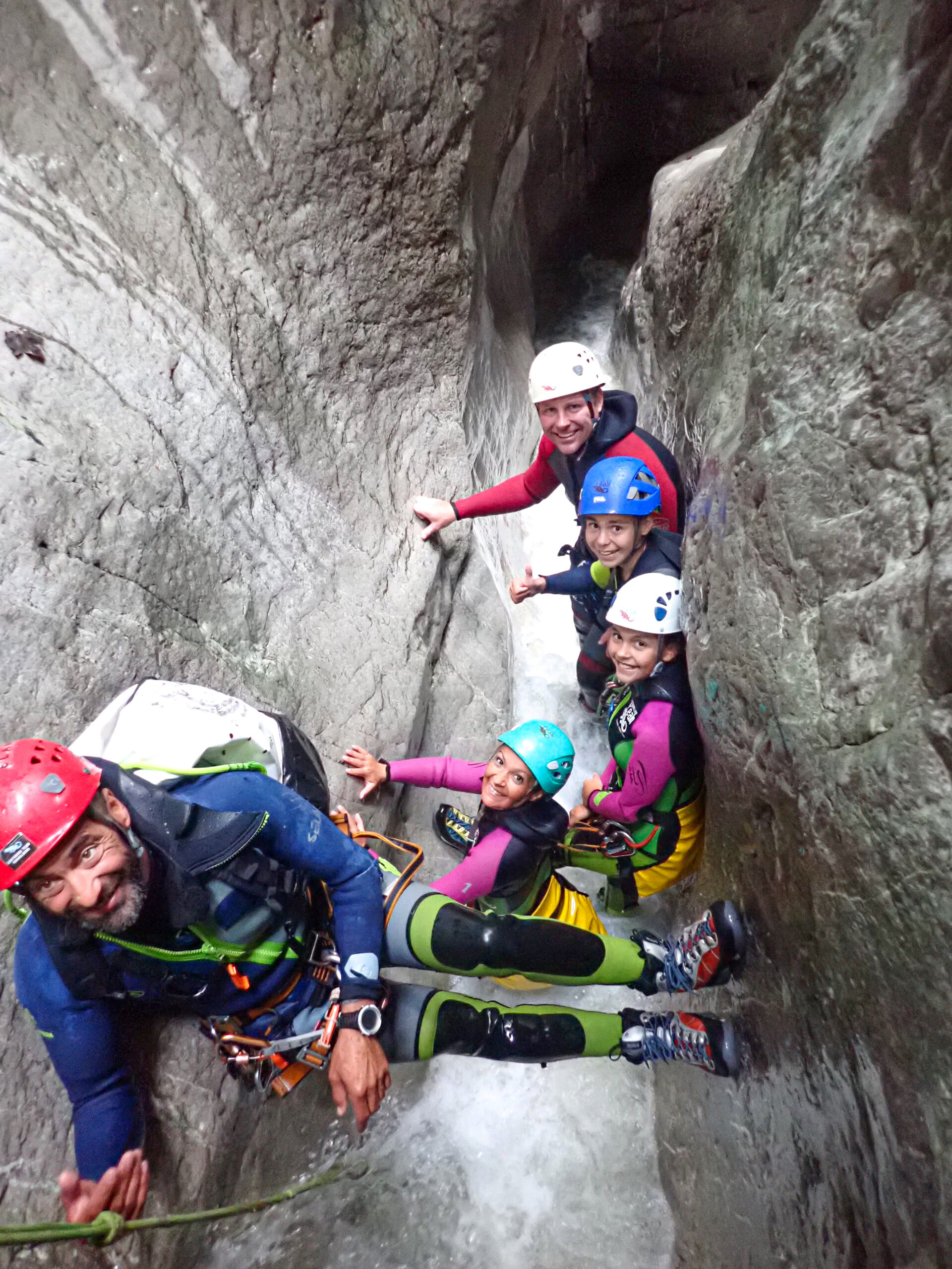 Familie mit Kindern beim Canyoning in einer engen Felsschlucht