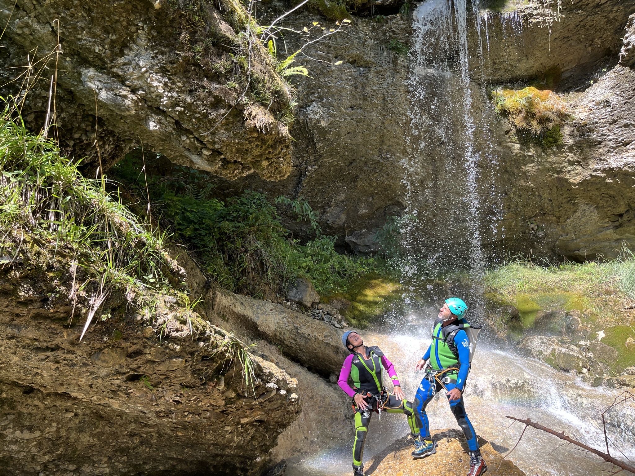 Zwei Personen beim Canyoning an einem Wasserfall in Vorarlberg