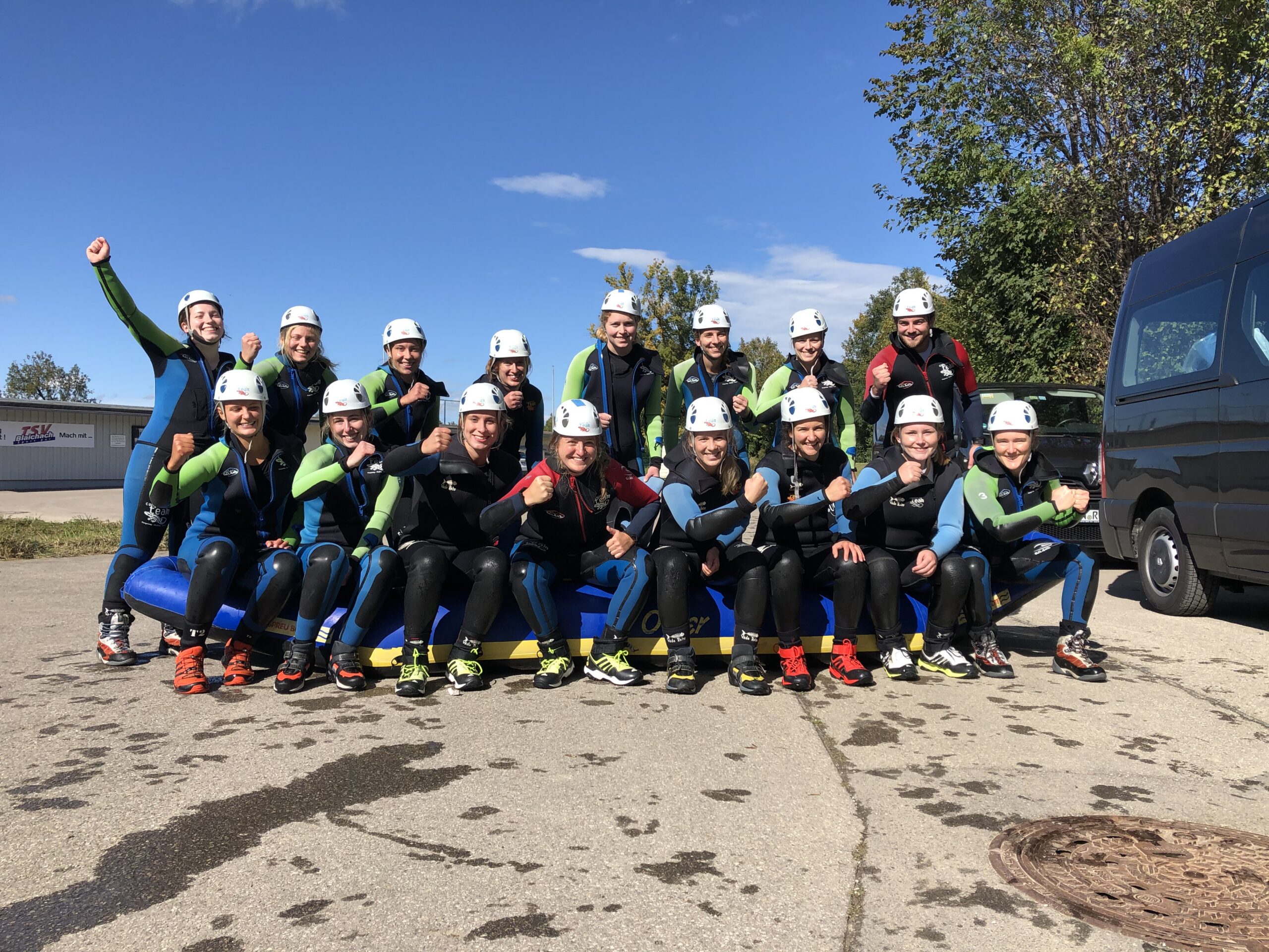 Rafting-Team in Neoprenanzügen vor dem Tourstart