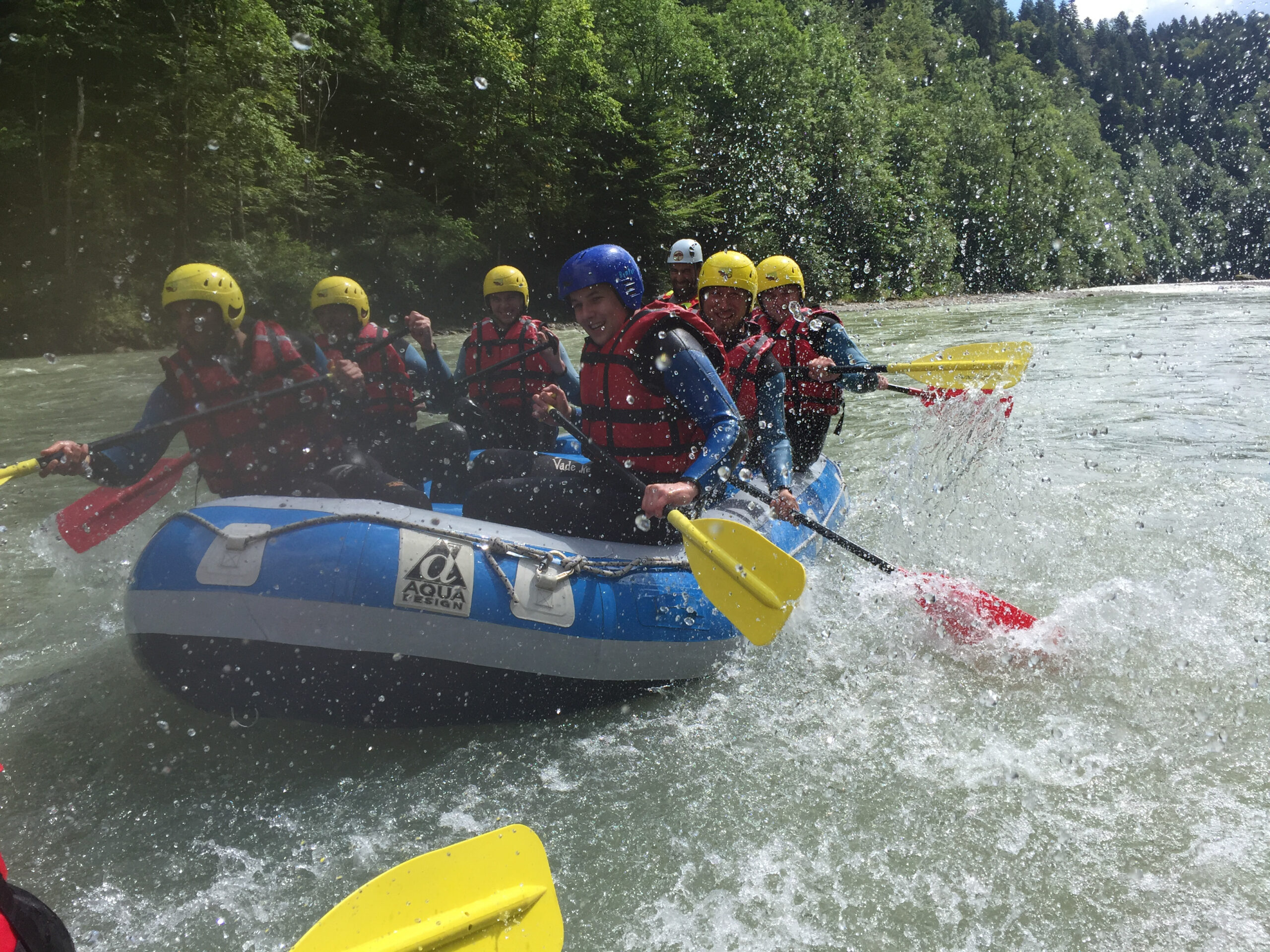 Rafting-Gruppe beim gemeinsamen Paddeln auf einem Fluss
