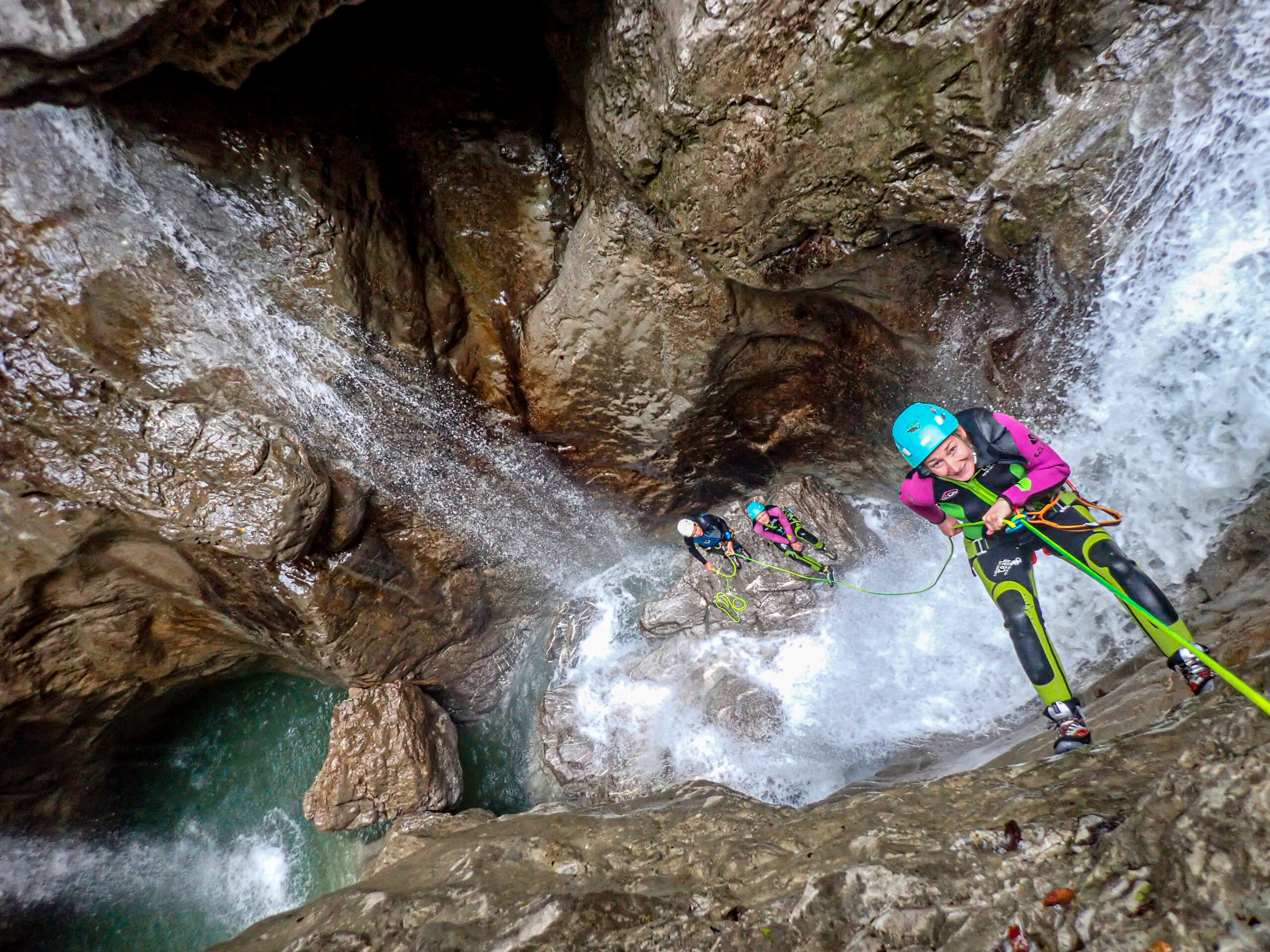 1. Zwei Personen beim Abseilen an einem Wasserfall in einer engen Schlucht